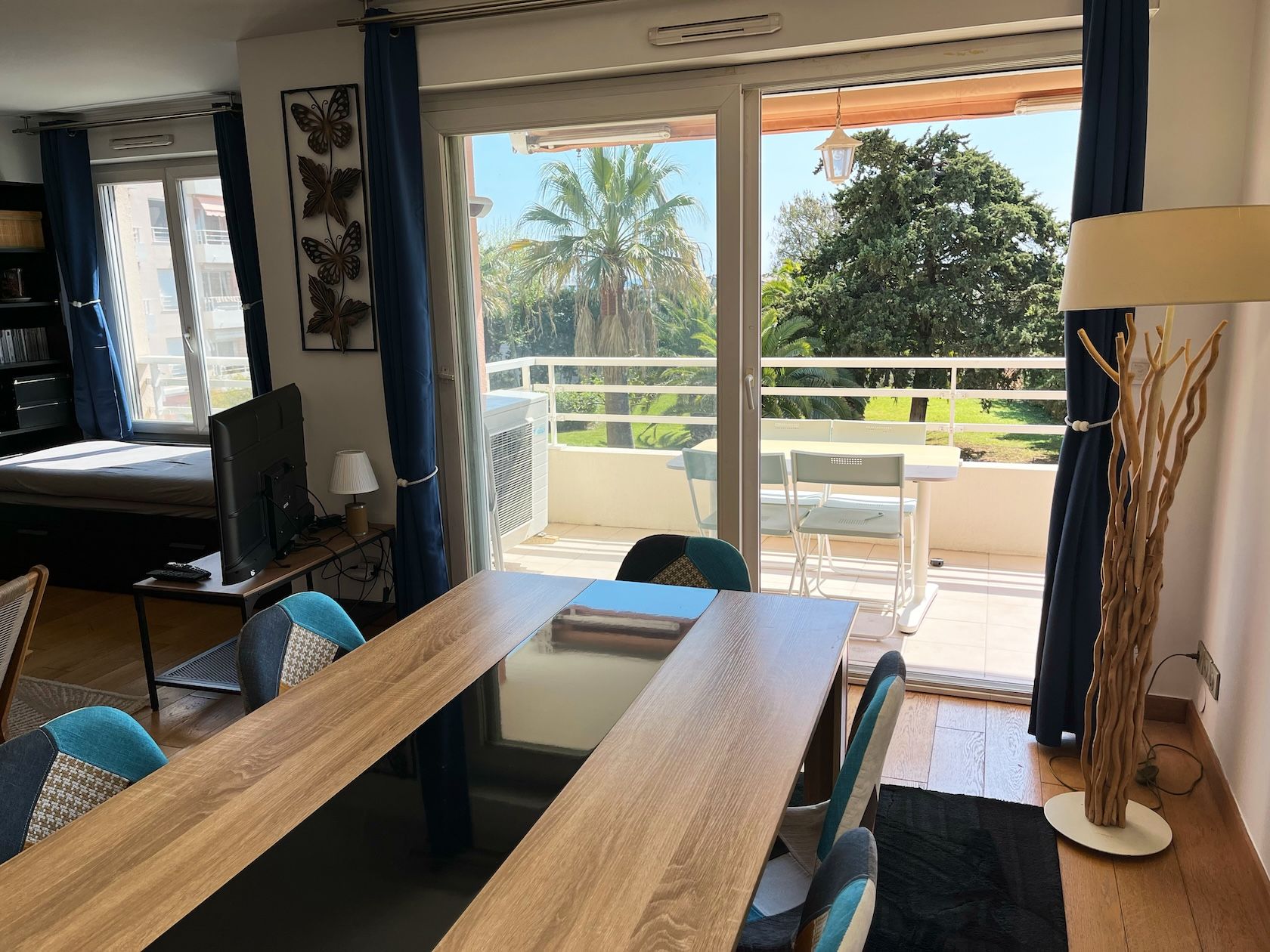 Dining table in front of the French windows open onto the terrace and palm trees