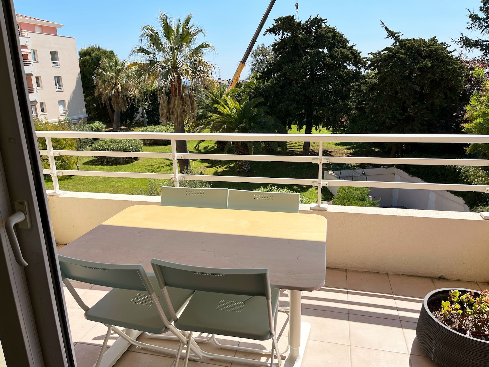 Terrace with a table, facing the garden and palm trees